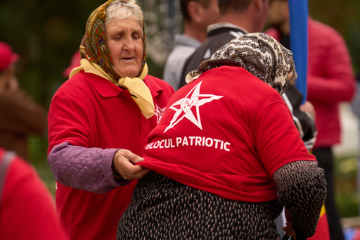 A woman gets help with taking off a red shirt decorated with the hammer and sickle after attending a rally of the Russia-friendly Patriotic Electoral Bloc in Chisinau, Moldova, Thursday, Sept. 25, 2025, ahead of parliamentary elections taking place on Sept. 28. (AP Photo/Vadim Ghirda) A woman gets help with taking off a red shirt decorated with the hammer and sickle after attending a rally of the Russia-friendly Patriotic Electoral Bloc in Chisinau, Moldova, Thursday, Sept. 25, 2025, ahead of parliamentary elections taking place on Sept. 28. (AP Photo/Vadim Ghirda)