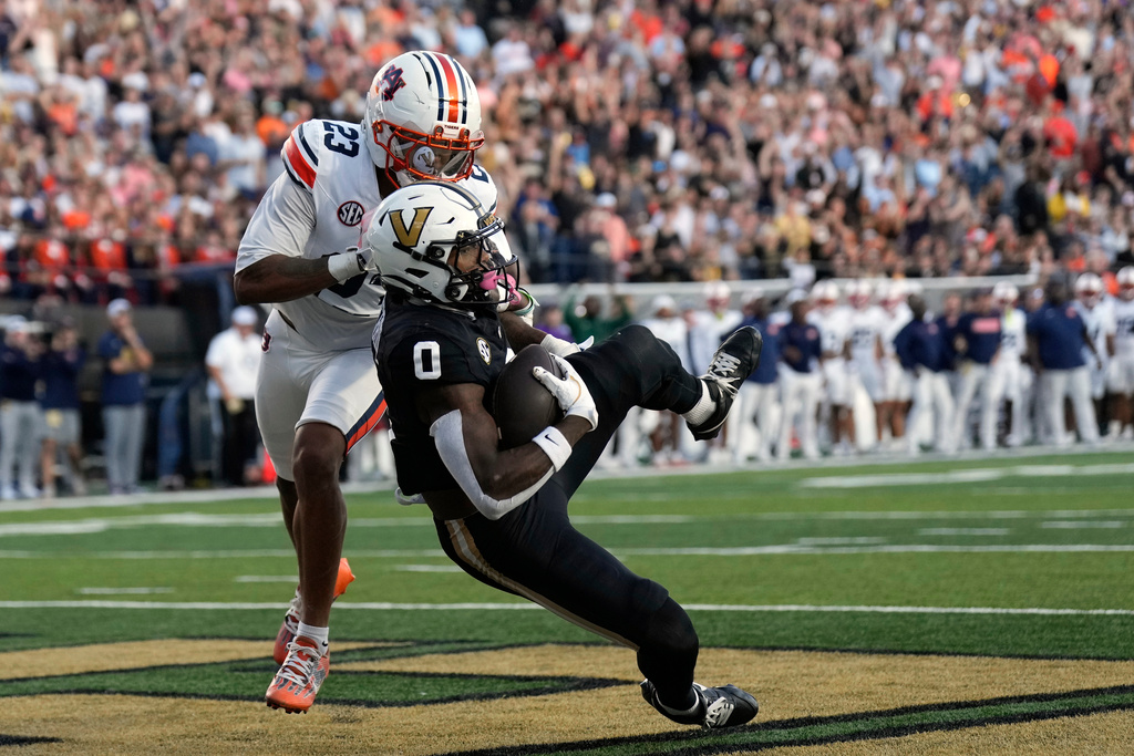Vanderbilt wide receiver Junior Sherrill (0) catches a touchdown pass in the end zone over Auburn cornerback Jay Crawford (23) during the first half of an NCAA college football game Saturday, Nov. 8, 2025, in Nashville, Tenn. (AP Photo/George Walker IV)