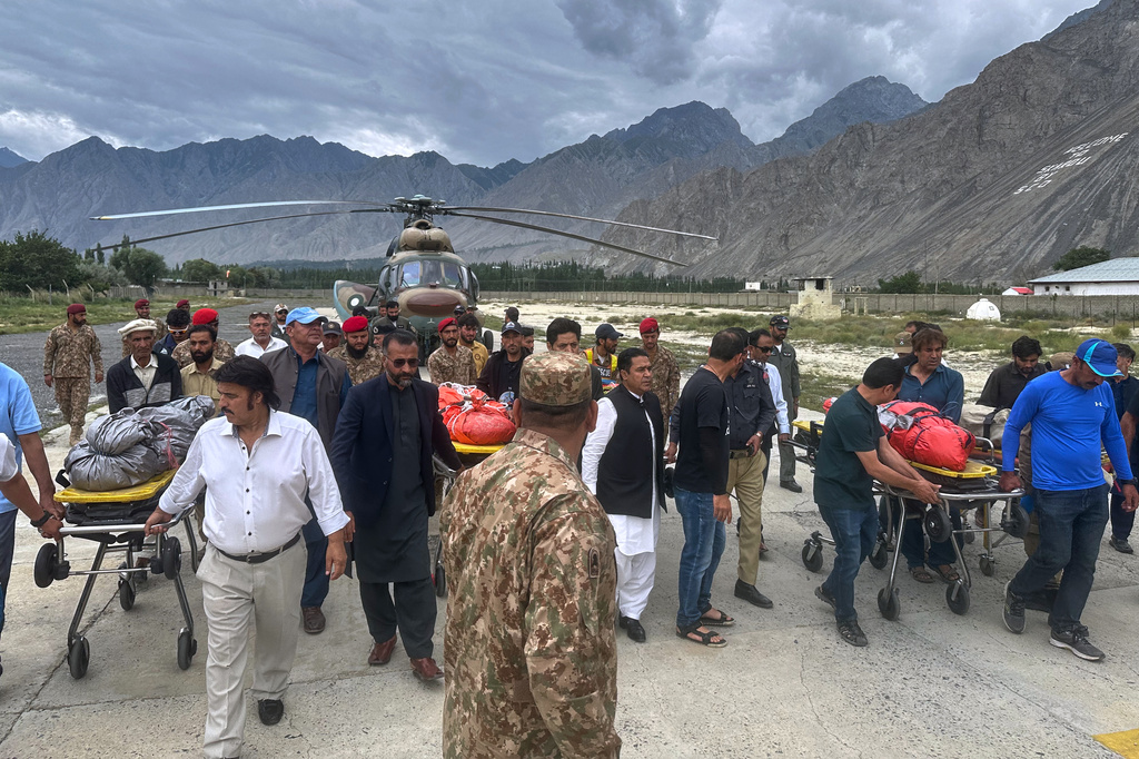 Pakistani army soldiers and volunteers prepare to load into ambulances, the bodies of climbers, that were recovered from Broad Peak nearly a week after an avalanche swept away a 10-member international expedition, upon arrival at a military base in Skardu, in northern Pakistan, Thursday, Aug. 6, 2026. (AP Photo/ M.H. Balti)