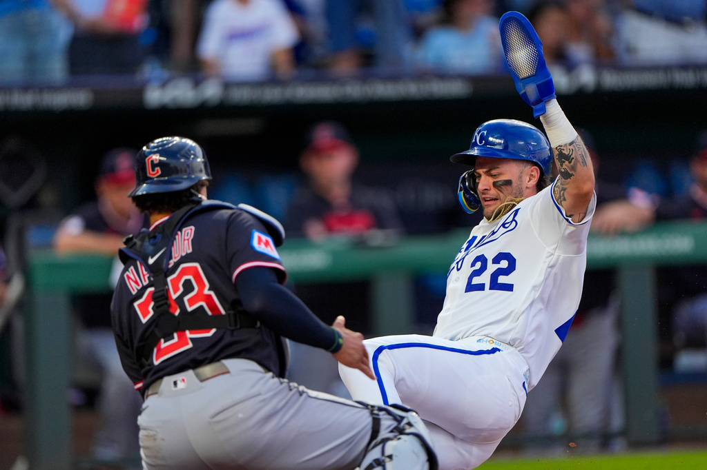 Kansas City Royals' Carter Jensen (22) beats the tag by Cleveland Guardians catcher Bo Naylor (23) to score on a single by Nick Loftin during the fourth inning of a baseball game Monday, May 4, 2026, in Kansas City, Mo. (AP Photo/Charlie Riedel)