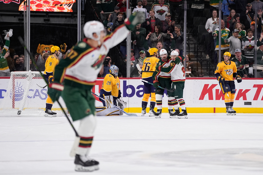 Minnesota Wild left wing Marcus Johansson (90), middle, hugs left wing Kirill Kaprizov (97), right, after scoring a goal during overtime of an NHL hockey game against the Nashville Predators, Tuesday, Nov. 4, 2025, in St. Paul, Minn. (AP Photo/Abbie Parr)