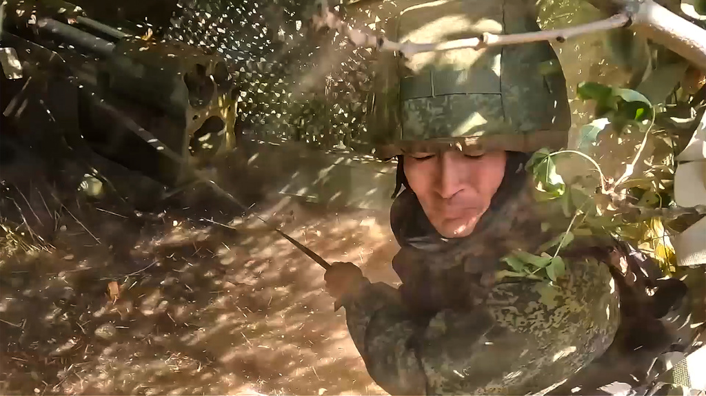 In this image made from video provided by Russian Defense Ministry Press Service on Tuesday, Oct. 28, 2025, a Russian soldier fires his Giatsint-B gun towards Ukrainian positions on an undisclosed location in Ukraine. (Russian Defense Ministry Press Service via AP)