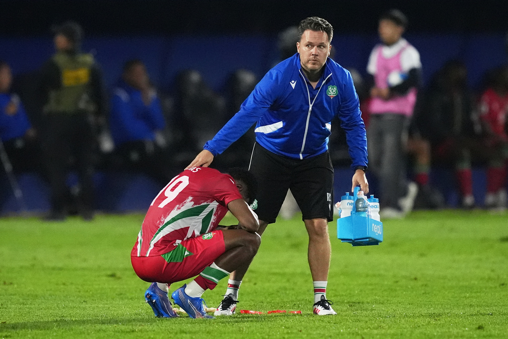 Suriname's Shaquille Pinas is consoled at the end of World Cup 2026 qualifying soccer match against Guatemala in Guatemala City, Tuesday, Nov. 18, 2025. (AP Photo/Moises Castillo)