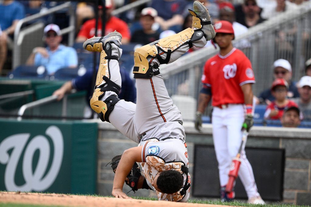 Baltimore Orioles catcher Samuel Basallo tumbles after he caught a popout hit by Washington Nationals' CJ Abrams in foul territory for an out during the third inning of a baseball game, Sunday, May 17, 2026, in Washington. (AP Photo/Nick Wass)