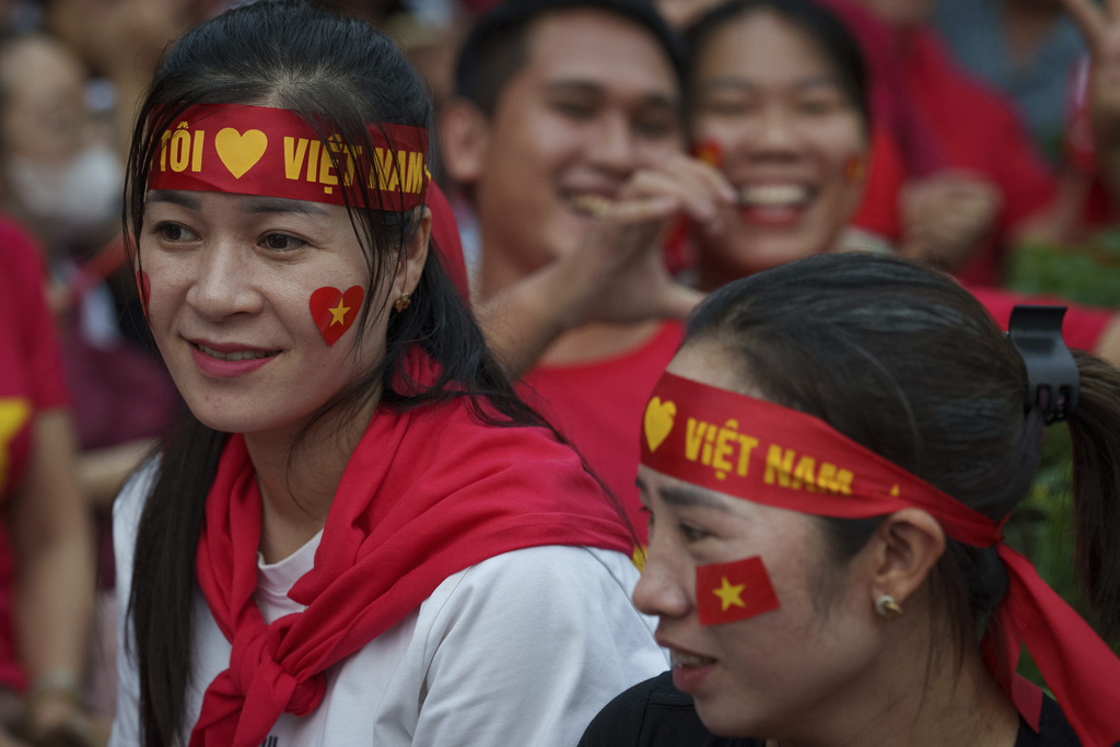 People wait for a military parade rehearsal for the Vietnam's 80th National Day celebration in Hanoi, Vietnam, Saturday, Aug. 30, 2025. (AP Photo/Vincent Thian)