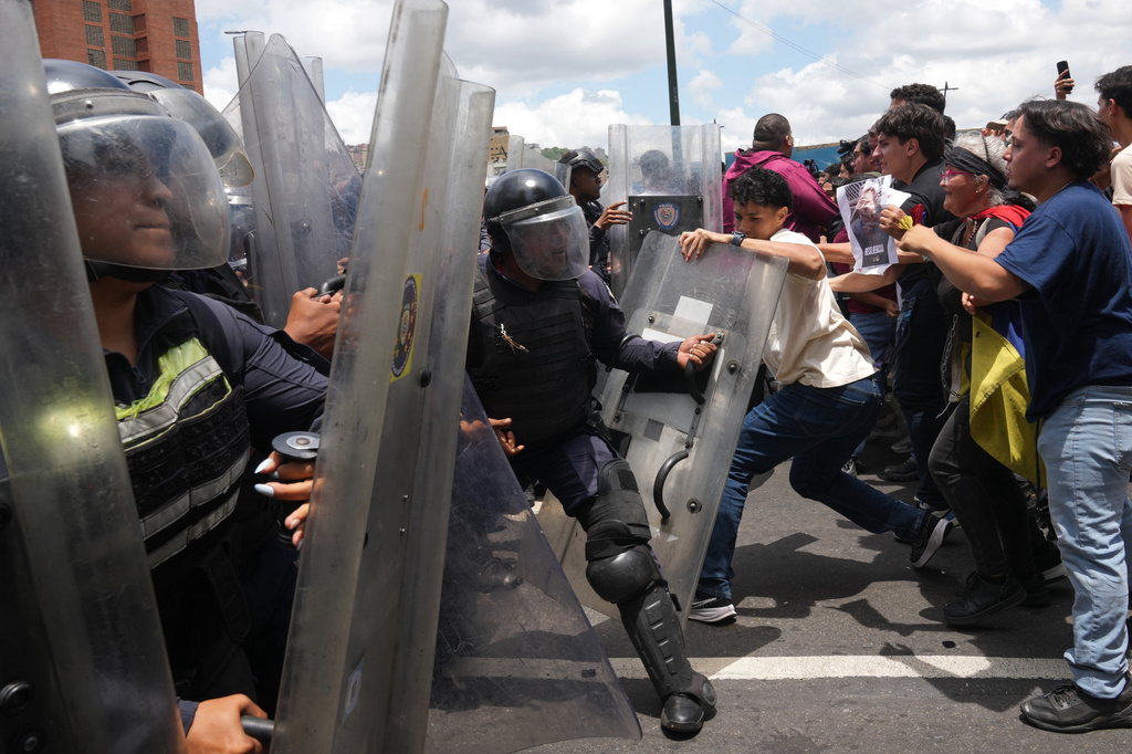 University students clash with Bolivarian National Police during a protest calling for justice after the death of Carmen Navas who died the previous day in Caracas, Venezuela, Monday, May 18, 2026, a week after the government confirmed that her missing son Victor Hugo Quero had died in custody following his arrest about a year earlier. (AP Photo/Ariana Cubillos)