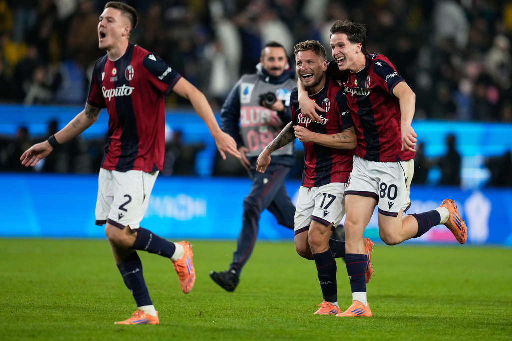 Bologna's Ciro Immobile, center, celebrates with teammates Emil Holm, left, and Giovanni Fabbian after scoring the winning goal during a penalty shoot out at the end of an Italian Super Cup semi-final soccer match between Bologna and Inter Milan in Riyadh, Saudi Arabia, Friday, Dec. 19, 2025. (AP Photo/Altaf Qadri)
