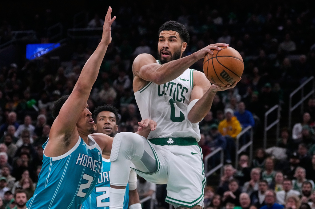 Boston Celtics forward Jayson Tatum (0) looks to pass while covered by Charlotte Hornets forward Grant Williams (2) during the second half of a NBA basketball game, Tuesday, April 7, 2026, in Boston. (AP Photo/Charles Krupa)