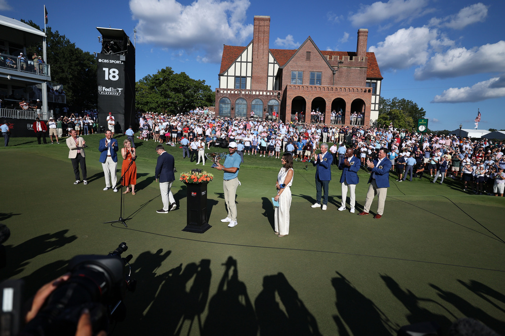 Scottie Scheffler holds the trophy after winning on the18th green during the final round of the PGA Tour Championship golf tournament Sunday, Aug. 30, 2026, in Atlanta. (AP Photo/Colin Hubbard)