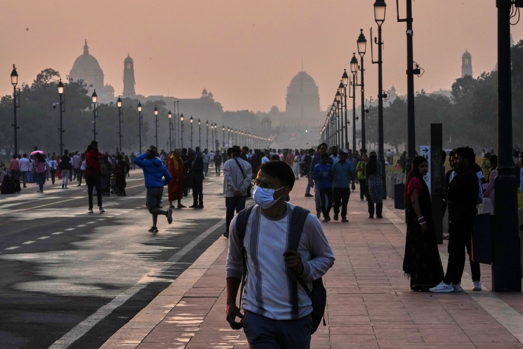 A person walks wearing a face mask to fight air pollution in the capital city New Delhi, India, Sunday, Nov. 9, 2025. (AP Photo/Manish Swarup)