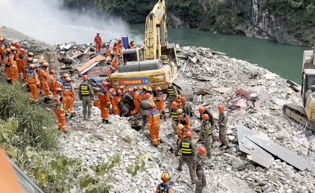 In this photo taken from video, rescuers pull a person out from the rubble after a landslide buried residential buildings in Pengshui County in southwestern China's Chongqing on Friday, July 17, 2026. (Tang via AP)