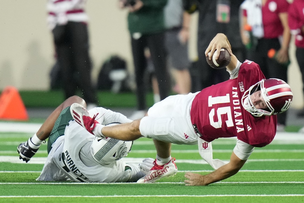 Indiana quarterback Fernando Mendoza (15) is tackled by Michigan State defensive lineman Kekai Burnett (51) during the second half of an NCAA college football game, Saturday, Oct. 18, 2025, in Bloomington, Ind. (AP Photo/AJ Mast)