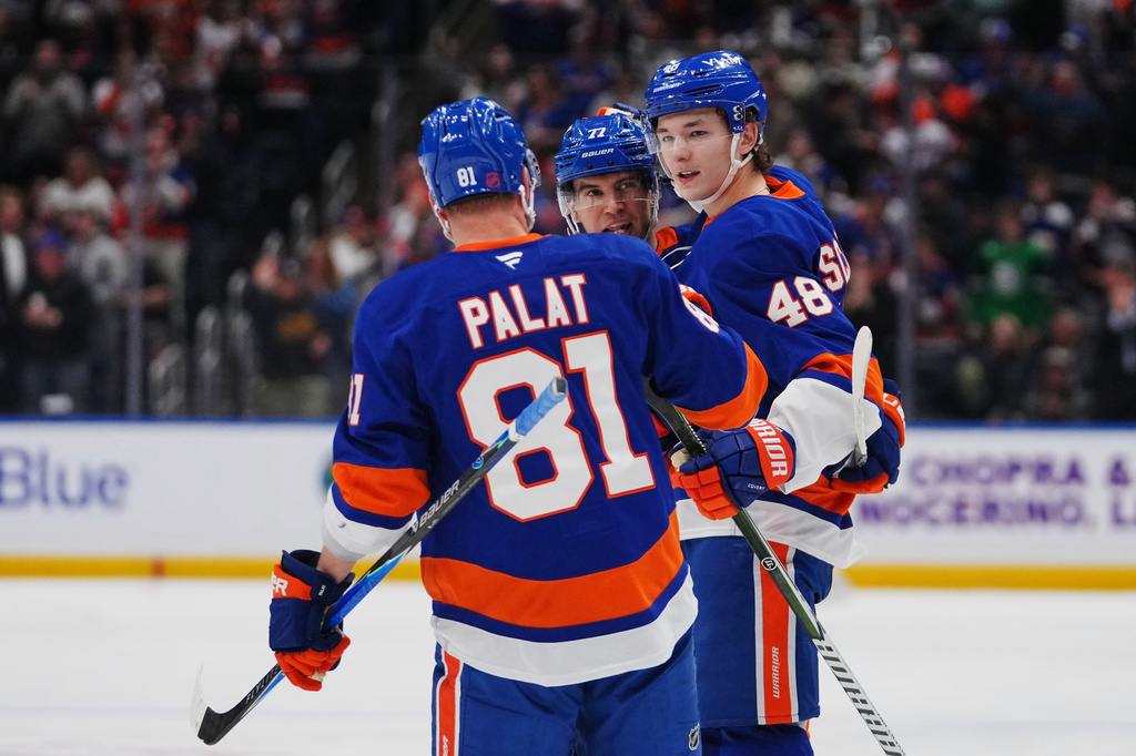 New York Islanders' Matthew Schaefer (48) celebrates with teammates Tony DeAngelo (77) andn Ondrej Palat (81) after scoring a goal during the second period of an NHL hockey game against the Toronto Maple Leafs Thursday, April 9, 2026, in Elmont, N.Y. (AP Photo/Frank Franklin II)