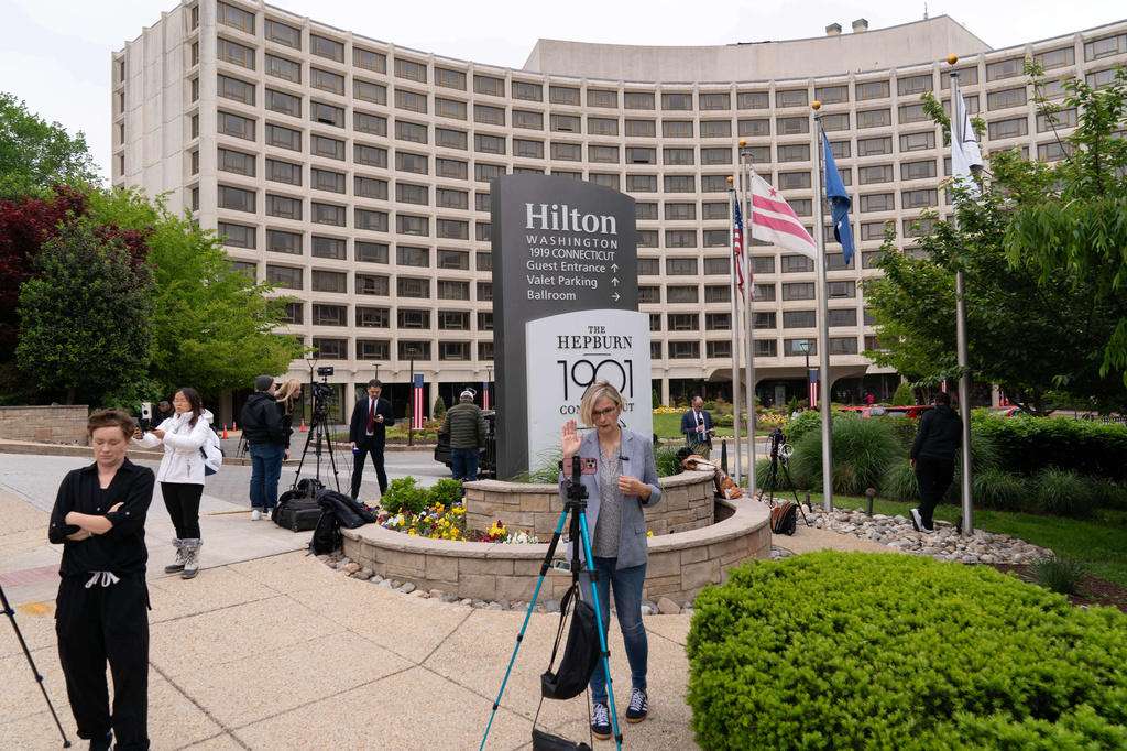 Journalists gather outside of the Washington Hilton Hotel, Sunday, April, 26, 2026, in Washington, the day after a gunman tried to storm into the hotel's ballroom during the White House Correspondents' Dinner. (AP Photo/Jose Luis Magana)