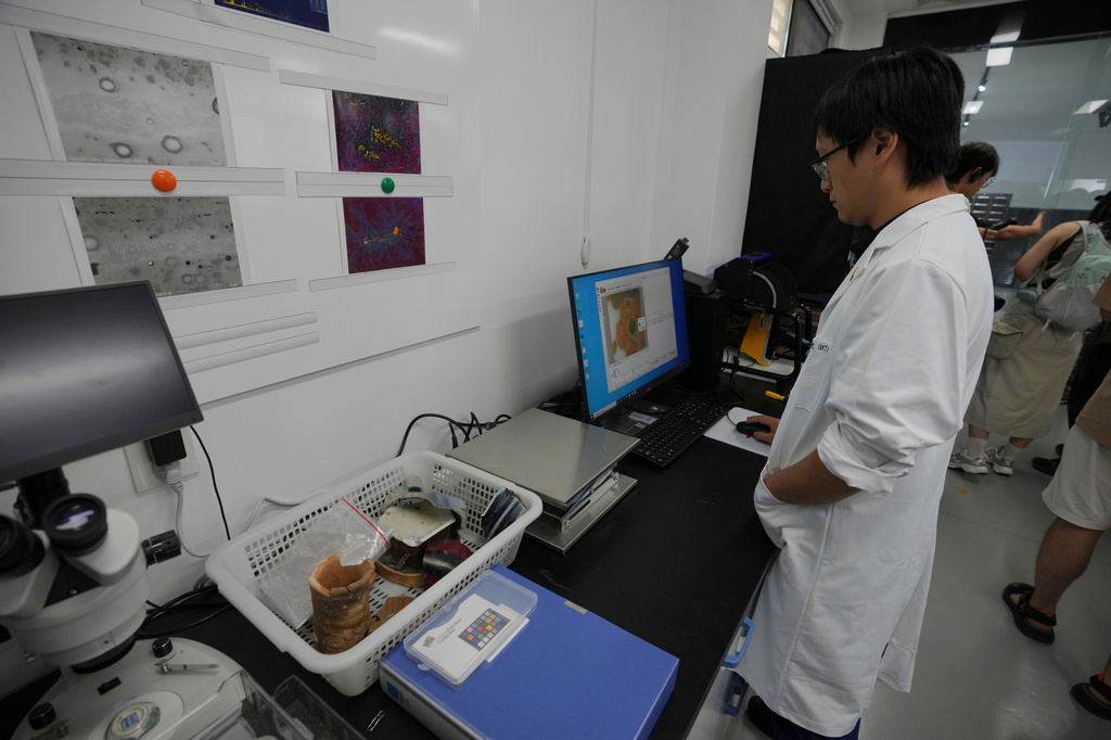 A researcher works with porcelain fragments at the Jingdezhen Imperial Kiln Institute which specializes in the research and restoration of ceramics excavated from the city's historic imperial kiln sites in Jingdezhen, in eastern China's Jiangxi province, Monday, Aug. 31, 2026. (AP Photo/Achmad Ibrahim)