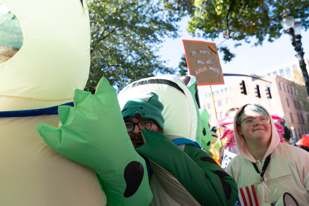 Seth Todd, who was in a frog costume when chemical spray was used on the costume outside a U.S. Immigration and Customs Enforcement facility in Portland, Ore., gathers with others during a "No Kings" protest in Portland, Ore., on Saturday, Oct. 18, 2025. (AP Photo/Jenny Kane)