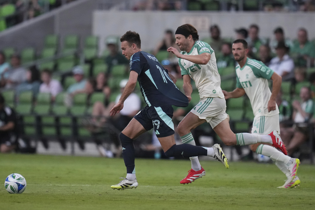 Austin FC midfielder Taishi Matsumoto, center, pulls Seattle Sounders usa Danny Musovski (19) away from the ball during the second half of an MLS soccer match in Austin, Texas, Sunday, Sept. 21, 2025. (AP Photo/Eric Gay)
