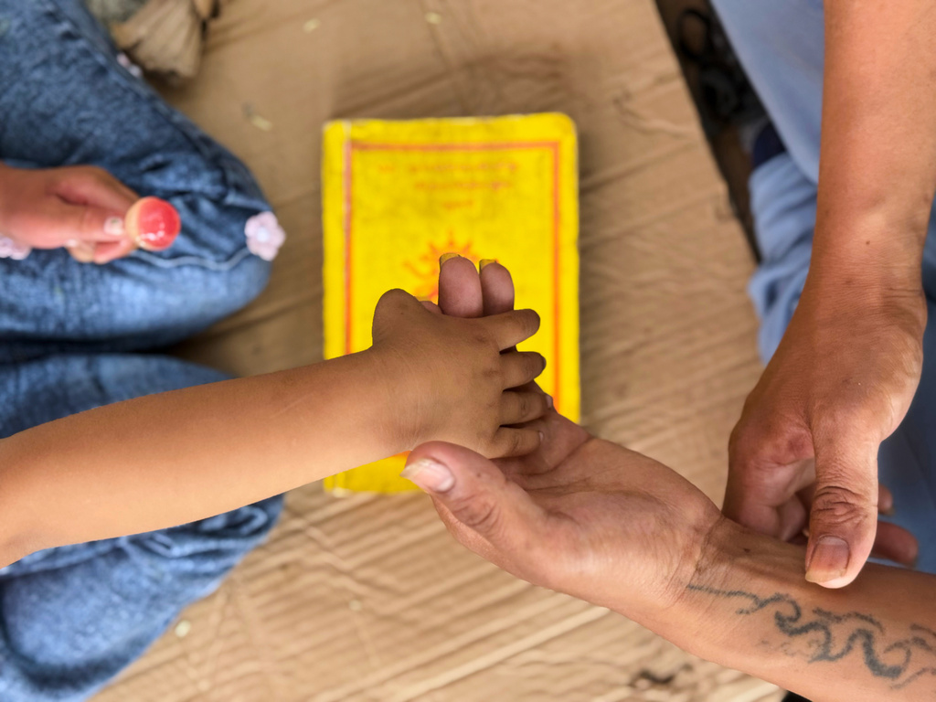 Survivor Tsering Gelbu Lama holds his daughter's hand as they spend time at a monastery where hundreds of survivors are seeking refuge in Kathmandu, Nepal, Monday, Aug. 31, 2026. (AP Photo/Niranjan Shrestha)