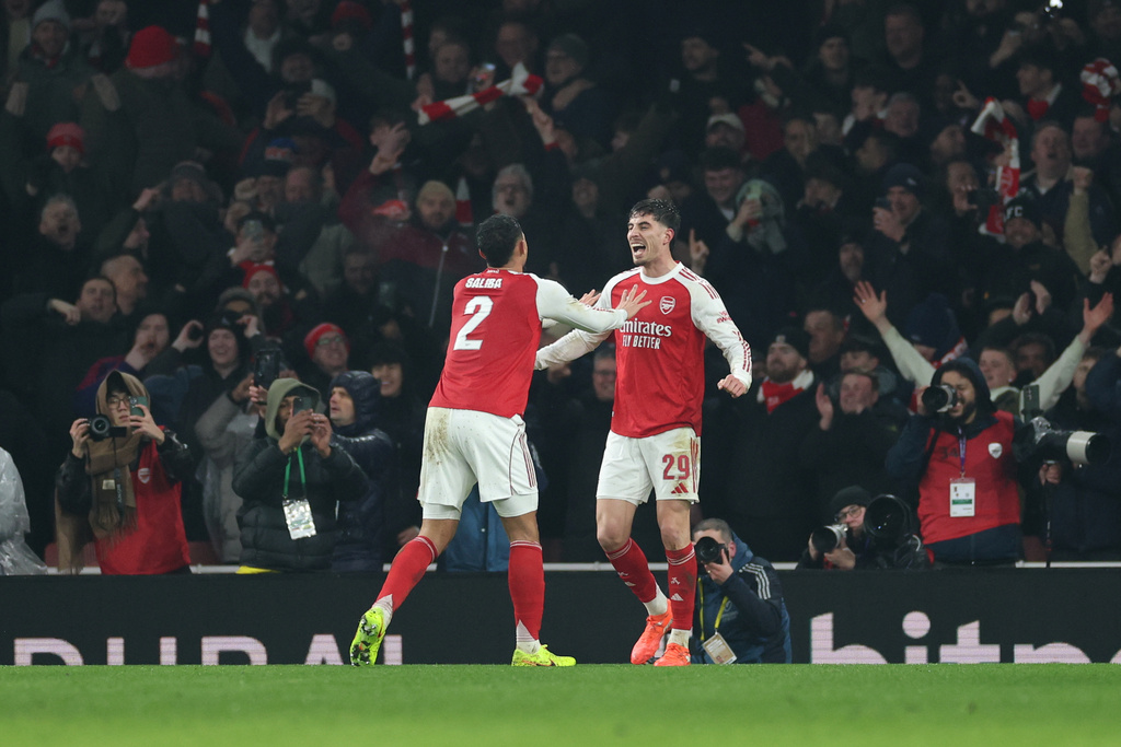 Arsenal's Kai Havertz, right, celebrates with Arsenal's William Saliba after scoring the opening goal during the English League Cup semifinal second leg soccer match between Arsenal and Chelsea in London, Tuesday, Feb. 3, 2026. (AP Photo/Ian Walton)
