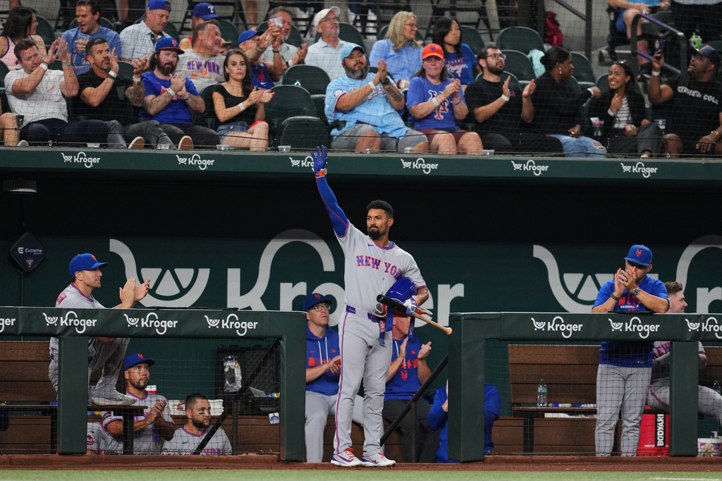 New York Mets' Marcus Semien acknowledges cheers from fans after a video tribute was played in honor of his time with the Texas Rangers in the second inning of a baseball game Tuesday, Sept. 22, 2026, in Arlington, Texas. (AP Photo/Tony Gutierrez)