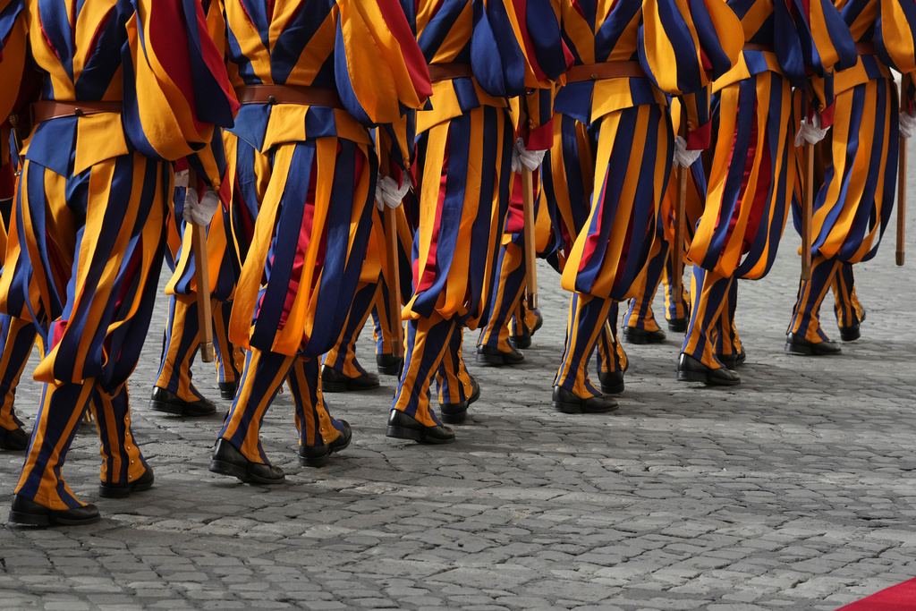 Swiss Guards march prior to the arrival of Britain's King Charles III and Queen Camilla arrive in the St. Damasus Courtyard at the Vatican for a state visit, where they will meet with Pope Leo XIV and pray with him in the Sistine Chapel, Thursday, Oct. 23, 2025. (AP Photo/Andrew Medichini)
