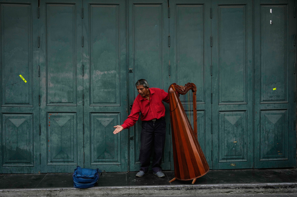 FILE- A harpist takes a bow after performing a song in downtown Lima, Peru, May 19, 2026. (AP Photo/Martin Mejia, File)