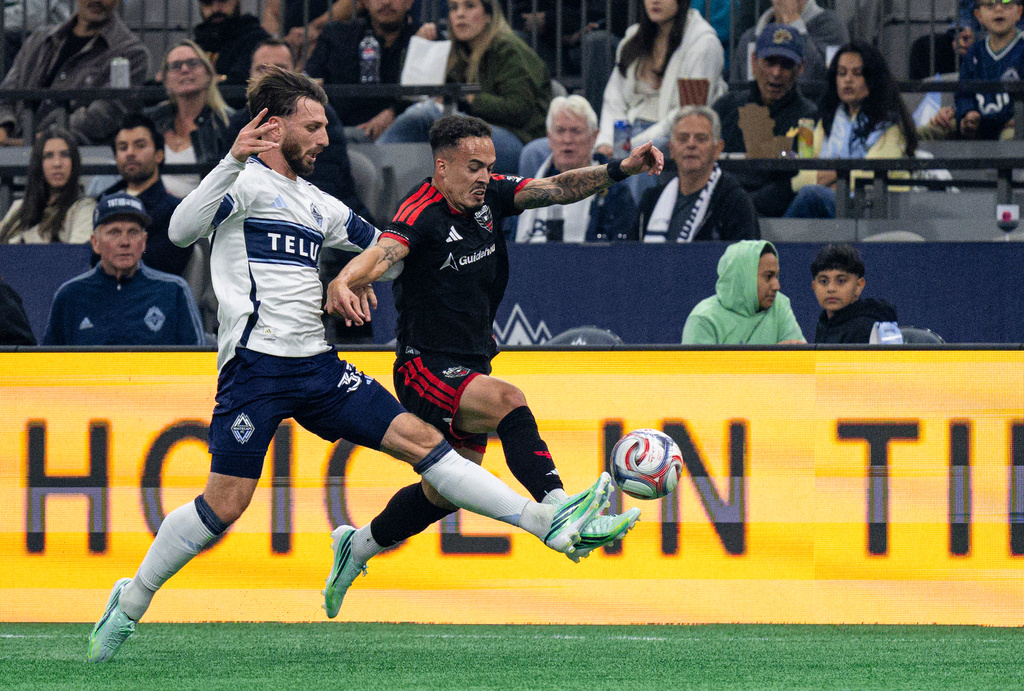 Vancouver Whitecaps' Tristan Blackmon, left, and D.C. United's Joao Peglow, right, vie for the ball during the first half of an MLS soccer match in Vancouver, British Columbia, Saturday, Sept. 26, 2026. (Jacob Mallari/The Canadian Press via AP)