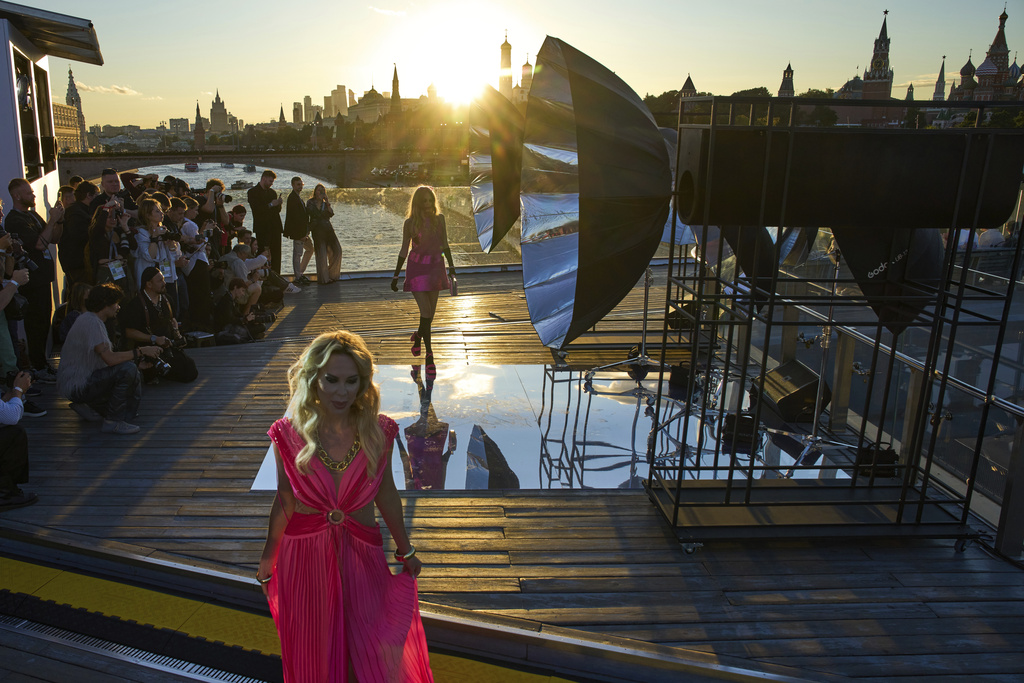 Model wear a creation by Russian designer Julia Dalakian on the Floating Bridge during sunset at Moscow Fashion Week at Zaryadye park in Moscow, Monday, Sept. 1, 2025, with the Kremlin in the background. (AP Photo/Alexander Zemlianichenko)