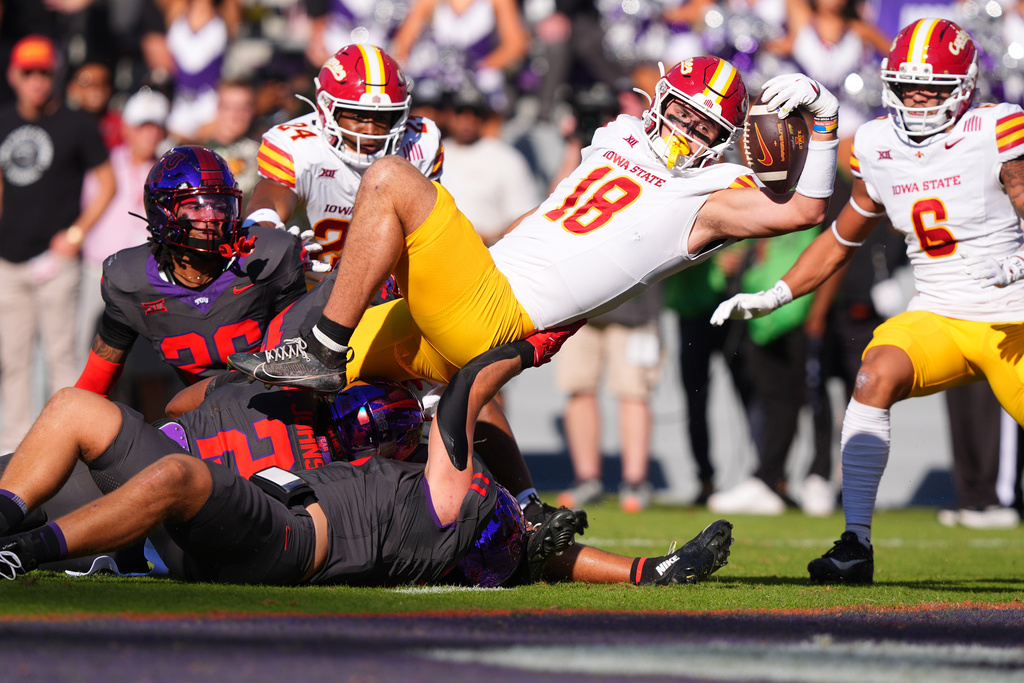 Iowa State tight end Benjamin Brahmer (18) scores a touchdown against TCU defenders Vernon Glover (26), Jamel Johnson (2) and Devean Deal (11) during the first half of an NCAA college football game Saturday, Nov. 8, 2025, in Fort Worth, Texas. (AP Photo/LM Otero)