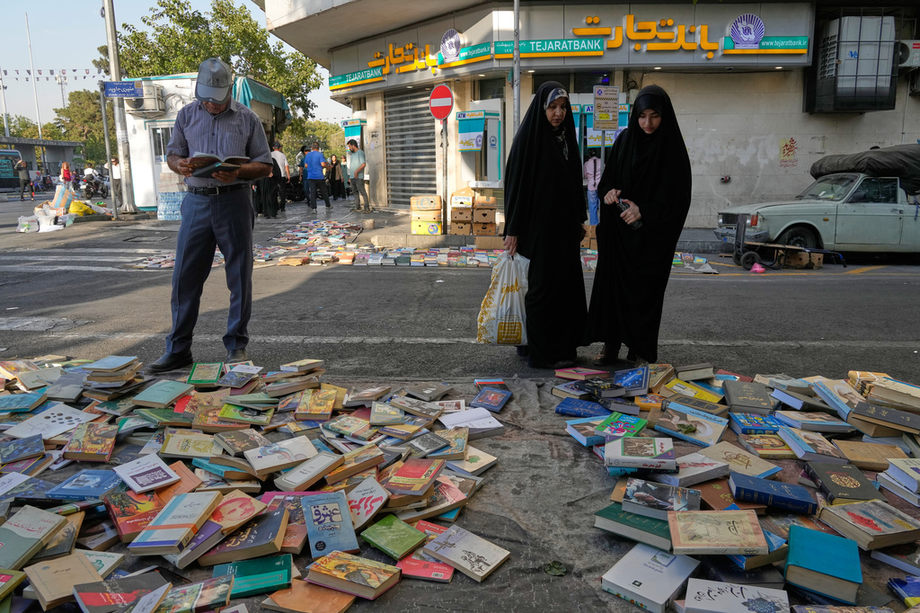 People look at books which are placed for sale on a street in downtown Tehran, Iran, Saturday, July 18, 2026. (AP Photo/Vahid Salemi)