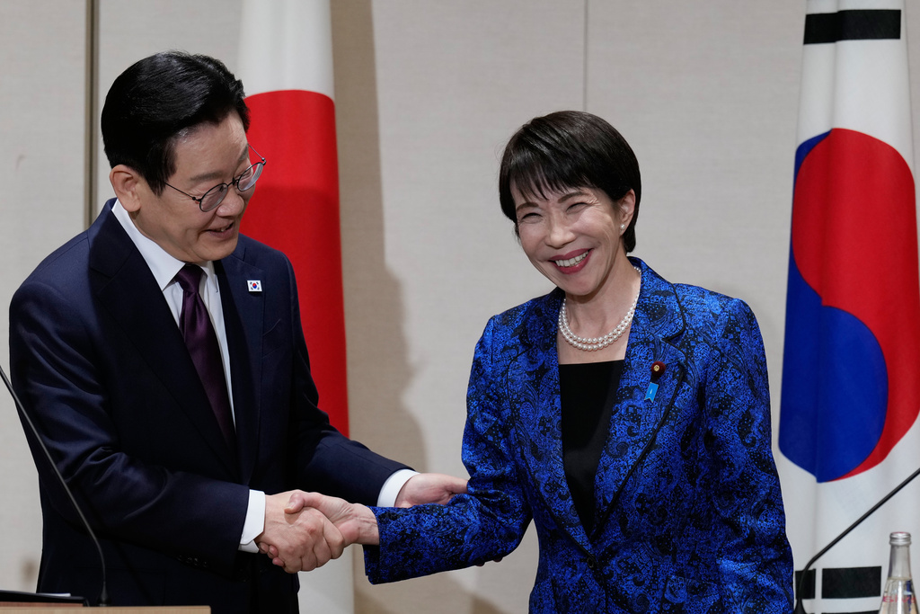 Japanese Prime Minister Sanae Takaichi, right, and South Korean President Lee Jae Myung pose for a photo as they shake hands during their joint news conference after their talk in Nara, western Japan, Tuesday, Jan. 13, 2026. (AP Photo/Eugene Hoshiko, Pool)