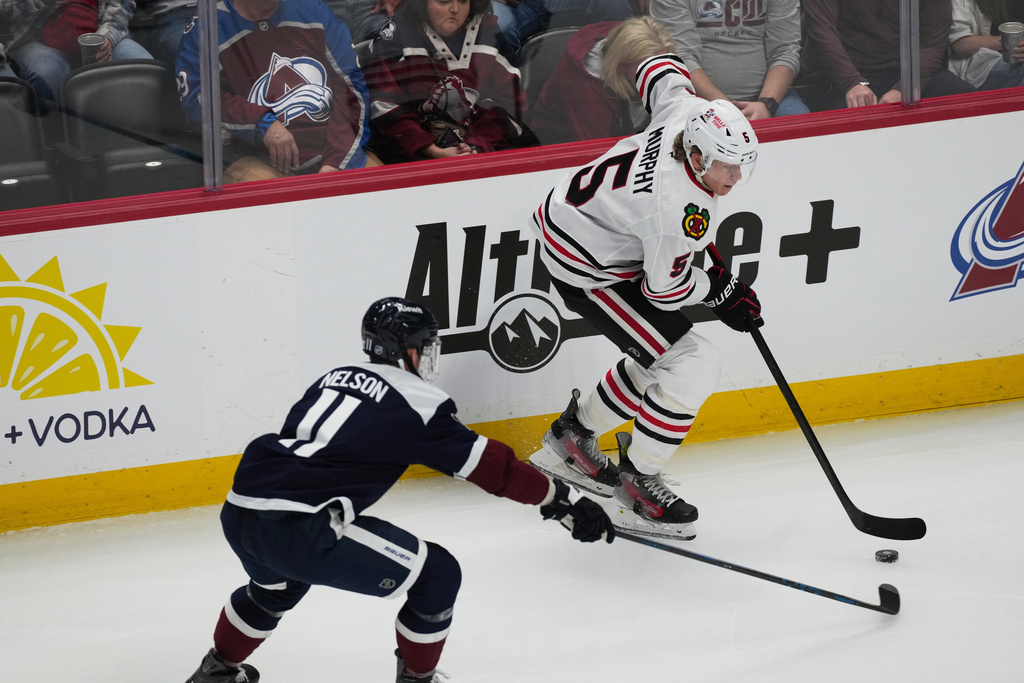 Chicago Blackhawks defenseman Connor Murphy, back, looks to pass the puck as Colorado Avalanche center Brock Nelson defends in the first period of an NHL hockey game Saturday, Feb. 28, 2026, in Denver. (AP Photo/David Zalubowski)