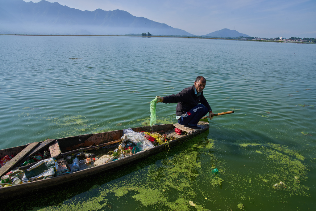 Mohammad Amin, a Kashmiri laborer employed by a nonprofit organization that collects garbage floating on Dal Lake, works on the outskirts of Srinagar, Indian controlled Kashmir, Monday, May 4, 2026. (AP Photo/Dar Yasin)