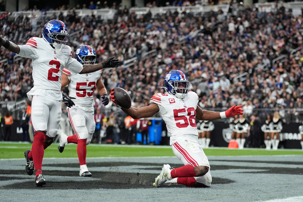 New York Giants linebacker Bobby Okereke (58) celebrates his interception with cornerback Deonte Banks (2) and linebacker Darius Muasau (53) during the first half of an NFL football game against the Las Vegas Raiders Sunday, Dec. 28, 2025, in Las Vegas. (AP Photo/John Locher)