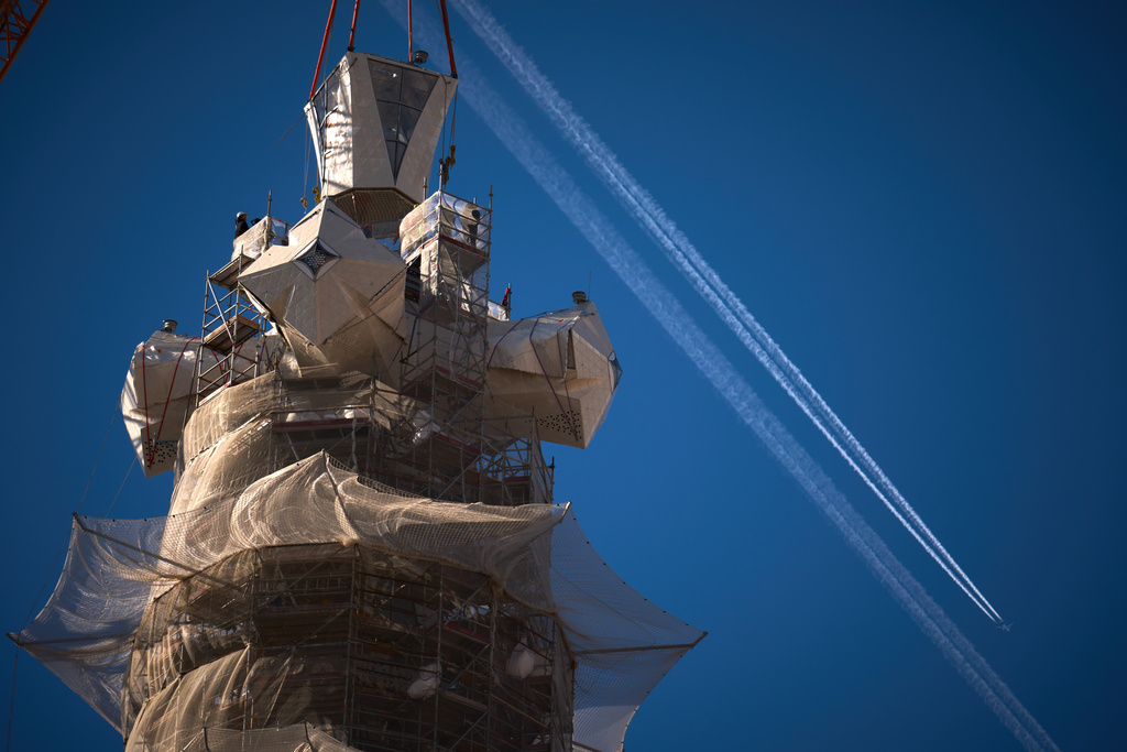 A crane lifts the upper arm of the cross onto the Tower of Jesus Christ at the Sagrada Familia in Barcelona, Spain, Friday, Feb. 20, 2026, reaching the basilica's maximum height of 172.5 meters (566 feet). (AP Photo/Emilio Morenatti)