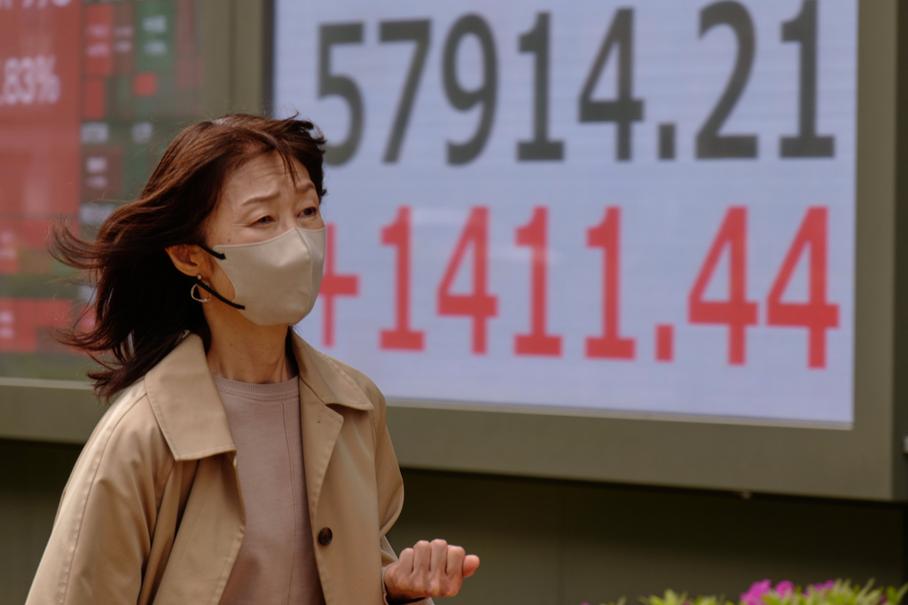 A person walks in front of an electronic stock board showing Japan's Nikkei index at a securities firm Tuesday, April 14, 2026, in Tokyo. (AP Photo/Eugene Hoshiko)