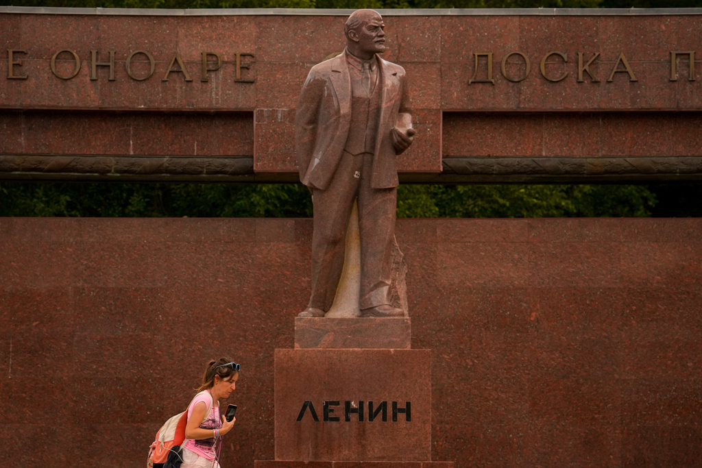 A woman walks past a statue of Lenin, with the words "Board of Honor" written in Cyrillic in Romanian and Russian in Chisinau, Moldova, Wednesday, Sept. 24, 2025, ahead of parliamentary elections taking place on Sept.28. (AP Photo/Vadim Ghirda)