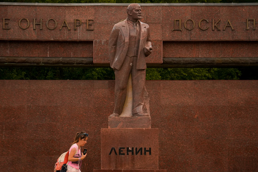 A woman walks past a statue of Lenin, with the words "Board of Honor" written in Cyrillic in Romanian and Russian in Chisinau, Moldova, Wednesday, Sept. 24, 2025, ahead of parliamentary elections taking place on Sept.28. (AP Photo/Vadim Ghirda) A woman walks past a statue of Lenin, with the words "Board of Honor" written in Cyrillic in Romanian and Russian in Chisinau, Moldova, Wednesday, Sept. 24, 2025, ahead of parliamentary elections taking place on Sept.28. (AP Photo/Vadim Ghirda)