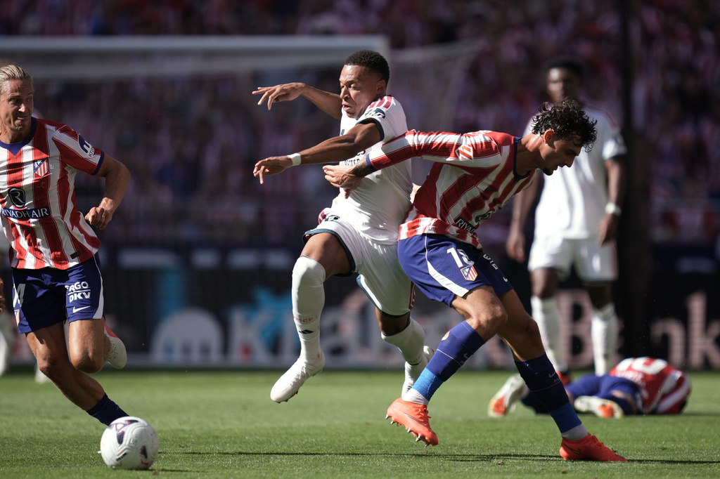 Real Madrid's Kylian Mbappe tries to get past Atletico Madrid's Marc Pubill, right, and Marcos Llorente during a Spanish La Liga soccer match between Atletico Madrid and Real Madrid in Madrid, Sunday, Sept. 20, 2026. (AP Photo/Bernat Armangue)