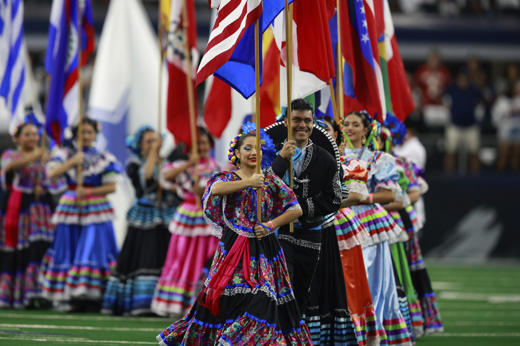 FILE - National flags from Latin American countries are displayed on the field during a celebration of Hispanic Heritage Month before an NFL football game between the Baltimore Ravens and Dallas Cowboys in Arlington, Texas, Sunday, Sept. 22, 2024. (AP Photo/Gareth Patterson, FILE)