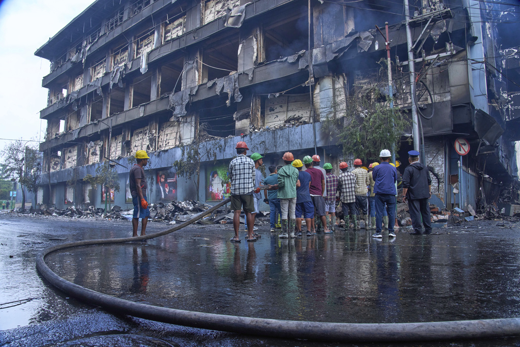 People work to douse a fire at Bhatbhatini shopping center after it was vandalized in Kathmandu, Nepal, Wednesday, Sept.10, 2025. (AP Photo/Niranjan Shrestha)