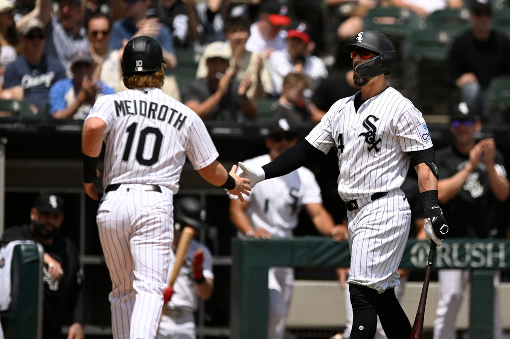 Chicago White Sox's Chase Meidroth (10) celebrates with Randal Grichuk, right, after scoring on a wild pitch during the first inning of a baseball against the Detroit Tigers in Chicago, Saturday, May 30, 2026. (AP Photo/Paul Beaty)