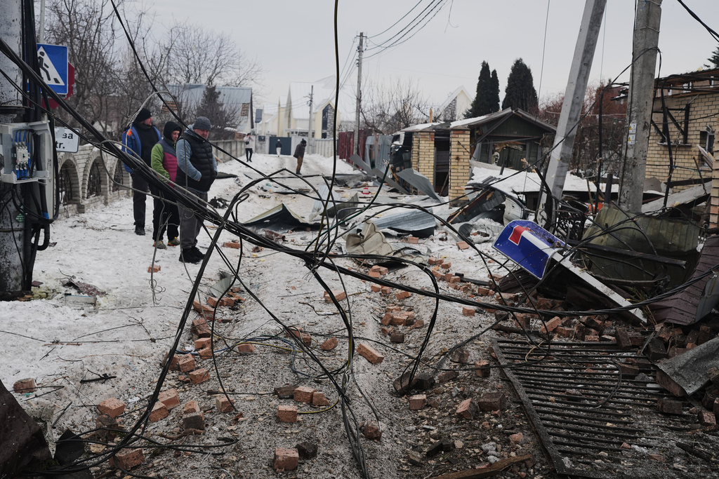 Local residents react after a Russian drone attack that damaged residential buildings in Kyiv, Ukraine, Sunday, Feb. 22, 2026. (AP Photo/Sergei Grits)