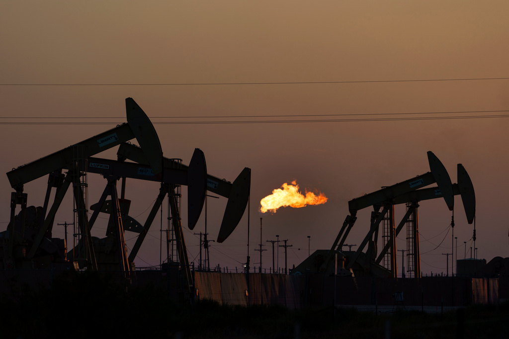 FILE - A flare burns off methane and other hydrocarbons as oil pumpjacks operate in the Permian Basin in Midland, Texas, on Oct. 12, 2021. (AP Photo/David Goldman, File)