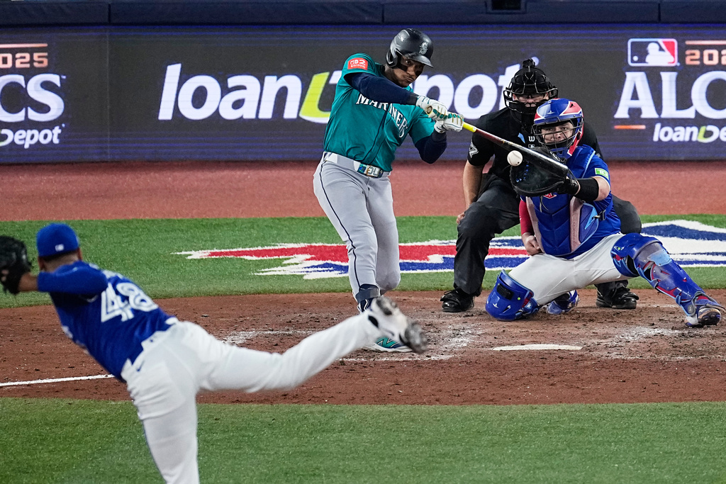 Seattle Mariners Jorge Polanco connects for an RBI single as Toronto Blue Jays pitcher Seranthony Domínguez (48) follows through during the eighth inning in Game 1 of baseball's American League Championship Series, Sunday, Oct. 12, 2025, in Toronto. (AP Photo/David J. Phillip)