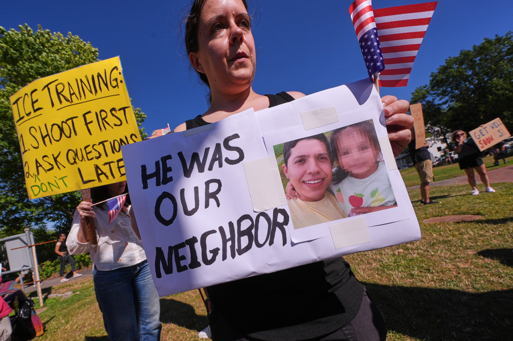 People hold signs in protest during a vigil for Johan Sebastian Duran Guerrero, a Colombian national who was shot and killed by an ICE agent, Friday, July 17, 2026, in Biddeford, Maine. (AP Photo/Charles Krupa)