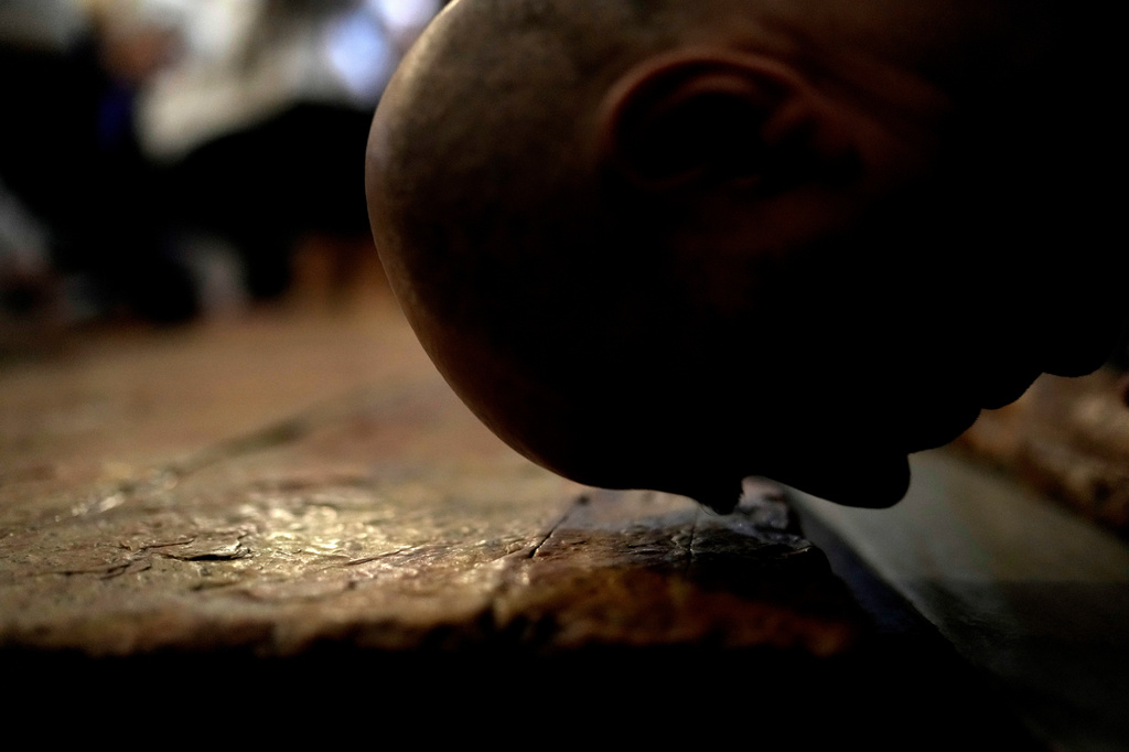 FILE - A Christian worshipper kisses the Stone of Unction, the stone slab traditionally claimed as the stone where Jesus' body was prepared for burial, in the Church of the Holy Sepulcher where many Christians believe Jesus was crucified, buried and rose from the dead, in the Old City of Jerusalem, on Good Friday, March 29, 2024. (AP Photo/Leo Correa, File)