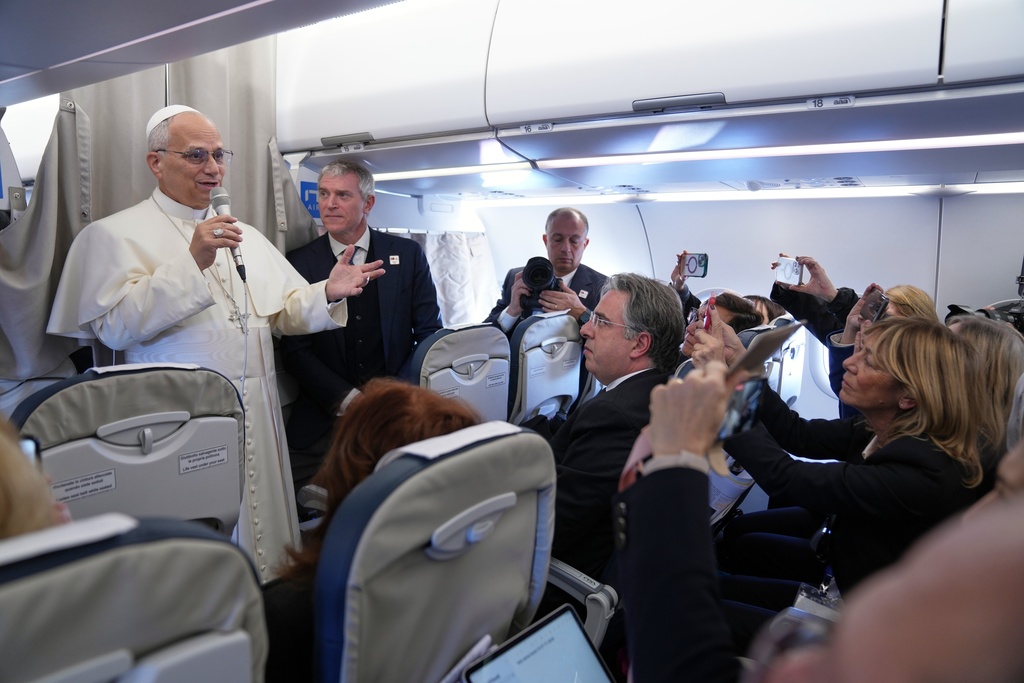 Pope Leo XIV greets reporters aboard a flight on his way to Ankara, Turkey, for a six-day trip to Turkey and Lebanon, Thursday, Nov. 27, 2025. (AP Photo/Domenico Stinellis, Pool)