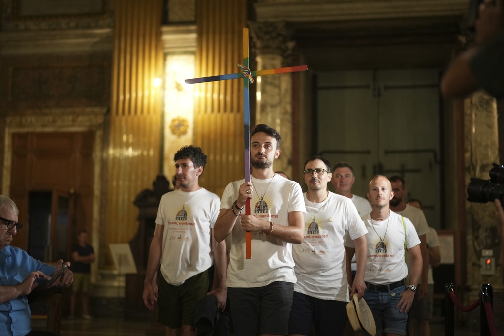 Andrea Mattei, holding a cross arrives with other members of the LGBTQ+ community to attend a vigil prayer in the Church of the Gesu' in central Rome, Friday, Sept. 5, 2025. (AP Photo/Andrew Medichini)