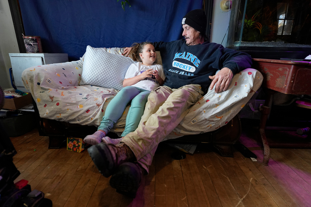 Gerard Berry talks with his daughter Brooklynn about her schoolwork, Friday, Nov. 7, 2025, in Baileyville, Maine. (AP Photo/Robert F. Bukaty)